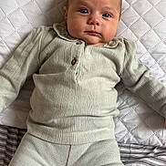 Lorïana a rejoint le concours — aidez-le/la à gagner de superbes lots ! baby, infant, child, face, blue_eyes, clothing, knitwear, pillow, bed, striped_bedding, quilted_pillow, indoor, lying_down, portrait, person, cute, calm, soft_texture, comfortable, home