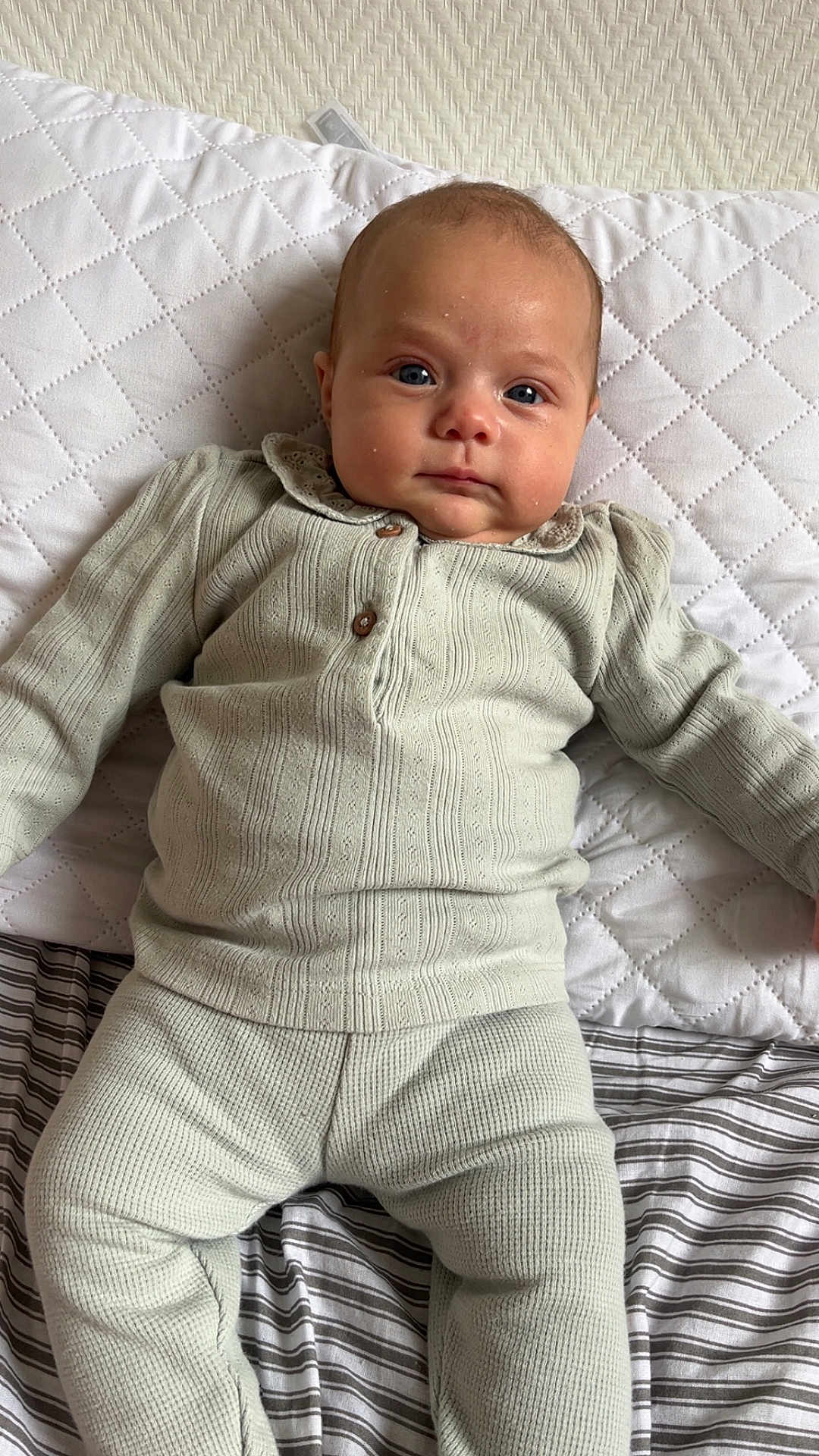 Lorïana a rejoint le concours — aidez-le/la à gagner de superbes lots ! baby, infant, child, face, blue_eyes, clothing, knitwear, pillow, bed, striped_bedding, quilted_pillow, indoor, lying_down, portrait, person, cute, calm, soft_texture, comfortable, home