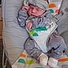 baby, baby_rocker, child, clothing, colorful, cozy, cute, fabric, headband, indoor, infant, newborn, onesie, patterned, peaceful, person, resting, sleeping, small, soft