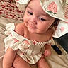 Nyla is registered to the contest to win money with this photo: baby, child, infant, cute, smiling, hat, strawberry_pattern, clothing, sitting, indoors, blanket, soft, skin, face, portrait, young_child, happy, cozy, person, apparel
