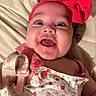 Nyla joined the competition — help win amazing prizes! baby, infant, smiling, headband, pink_bow, floral_dress, happy, face, cheeks, closeup, cute, child, person, indoors, lying_down, fabric, button, skin, eyes, mouth