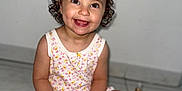 Isabelle a rejoint le concours — aidez-le/la à gagner de superbes lots ! child, toddler, smiling, curly_hair, pink_bows, sitting, floor, tile_floor, romper, floral_pattern, happy, cute, indoors, portrait, baby, young_child, fun, playful, skin, person