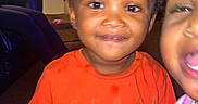 Kay'Den joined the competition — help win amazing prizes! child, toddler, indoor, orange_shirt, smiling, face, person, carpet, window, wood_paneling, furniture, joyful, curious, portrait, candid, home, living_room, person_holding, casual_clothing, two_children