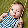 baby, infant, child, face, eyes, hands, rope, swing, striped_clothing, blue_and_white, texture, green_background, portrait, closeup, cute, curious, soft_lighting, skin, young, indoor