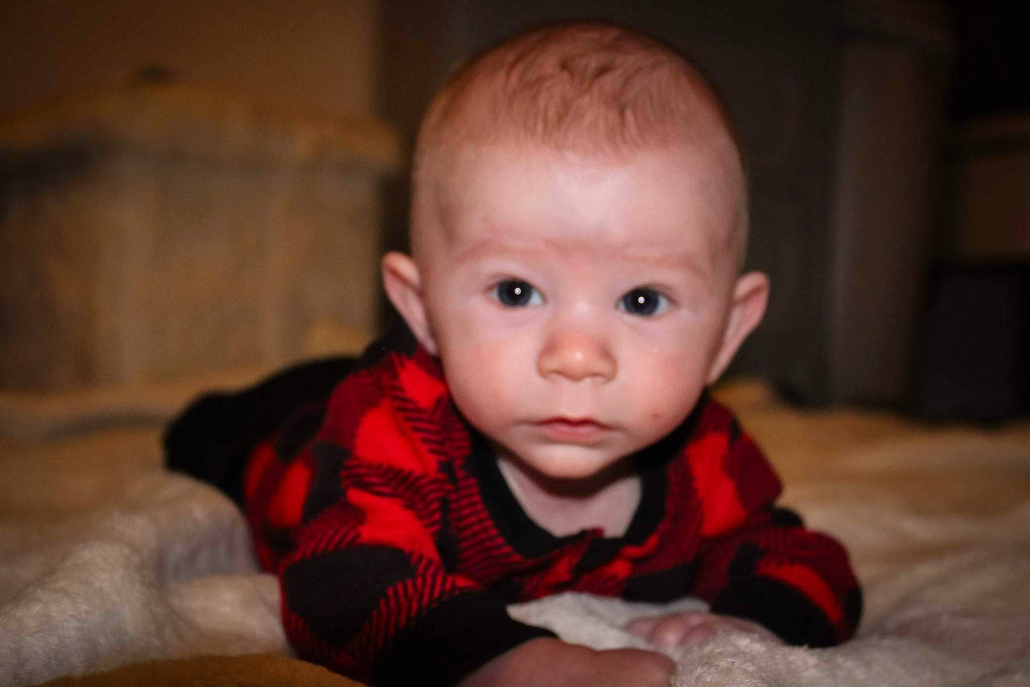 Bryson is registered to the contest to win money with this photo: baby, baby_toddler_clothing, cheek, child, comfort, darkness, flash_photography, flooring, fun, fur, hardwood, iris, pattern, person, portrait_photography, sitting, skin, sleeve, smile, toddler