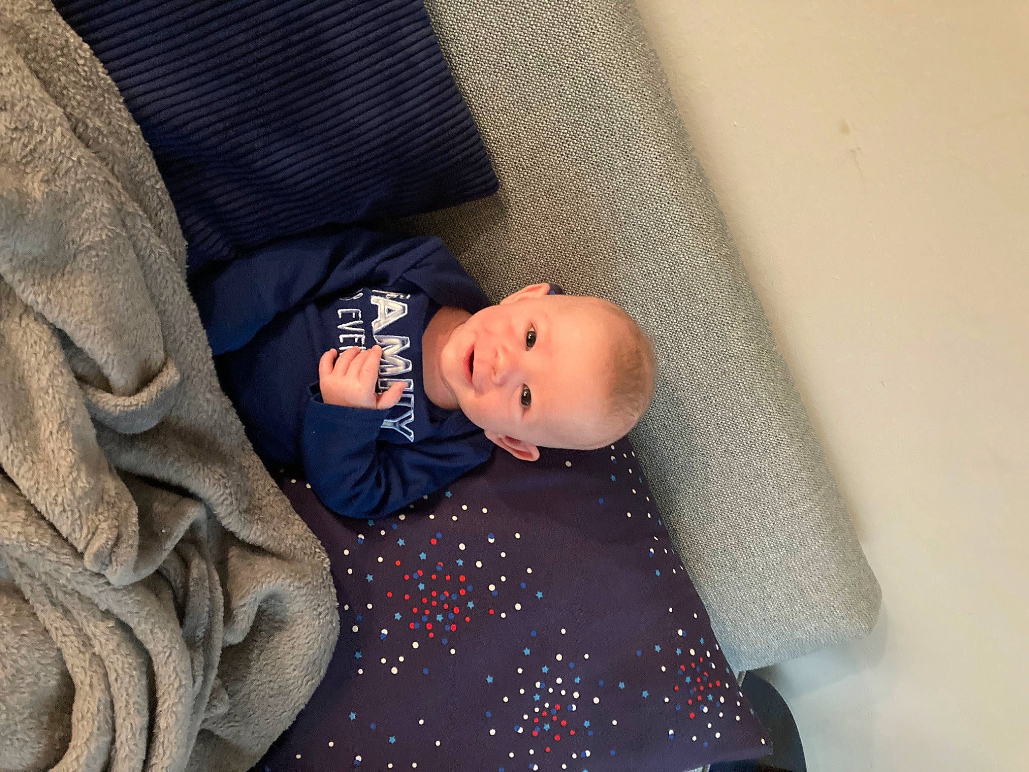 Bryson is registered to the contest to win money with this photo: baby, baby_products, baby_sleeping, baby_toddler_clothing, beanie, bedding, child, comfort, couch, electric_blue, eye, linens, pattern, person, room, sitting, sleeve, textile, tints_and_shades, toddler