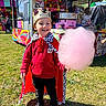Evan participe au concours pour gagner de l'argent avec cette photo : child, boy, cotton_candy, crown, cape, red_hoodie, black_pants, black_shoes, grass, fairground, stall, outdoor, daylight, smiling, happy, festival, colorful, fun, portrait, celebration