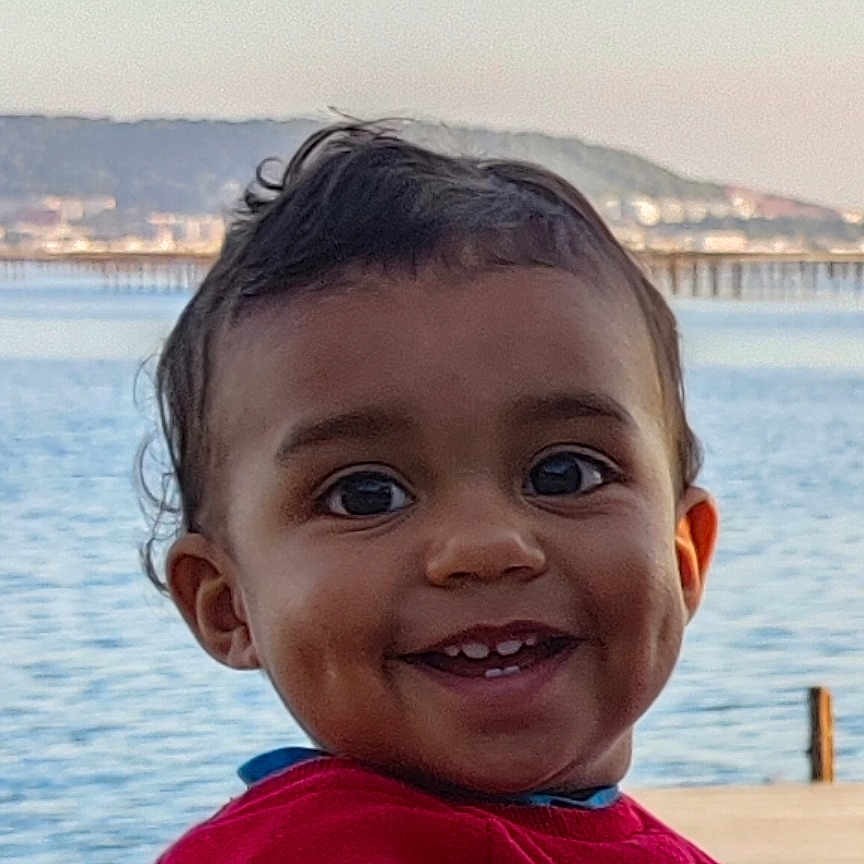 Elyot participe au concours pour gagner de l'argent avec cette photo : child, closeup, clothing, cute, daylight, dimples, face, happy, hills, lake, nature, outdoor, person, portrait, red_sweater, sky, smiling, toddler, water, young_child