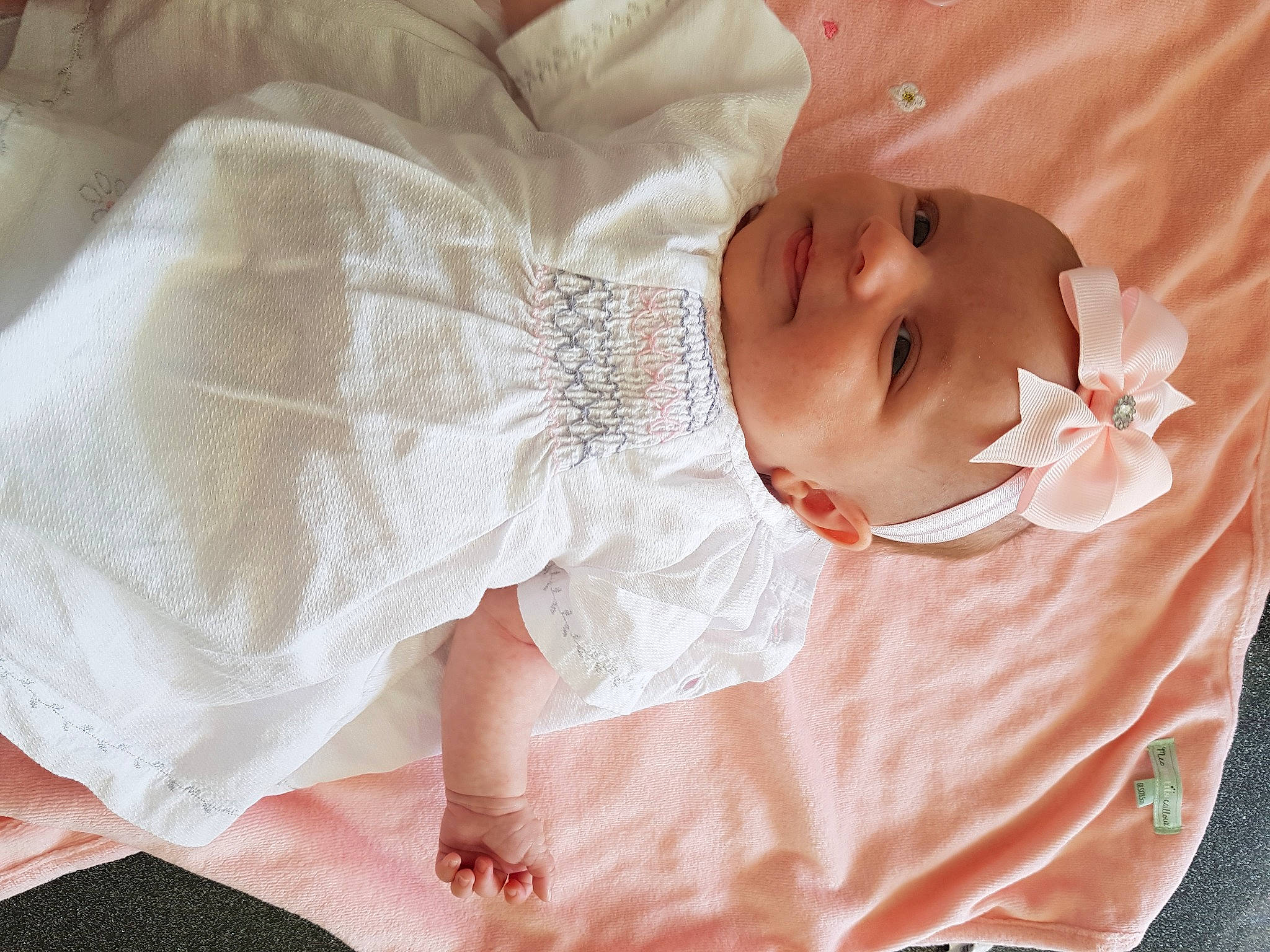 Alix participe au concours pour gagner de l'argent avec cette photo : arm, baby, baby_toddler_clothing, bridal_accessory, comfort, dress, embellishment, eye, eyelash, facial_expression, finger, hand, happy, hat, headwear, human_body, iris, person, skin, sleeve