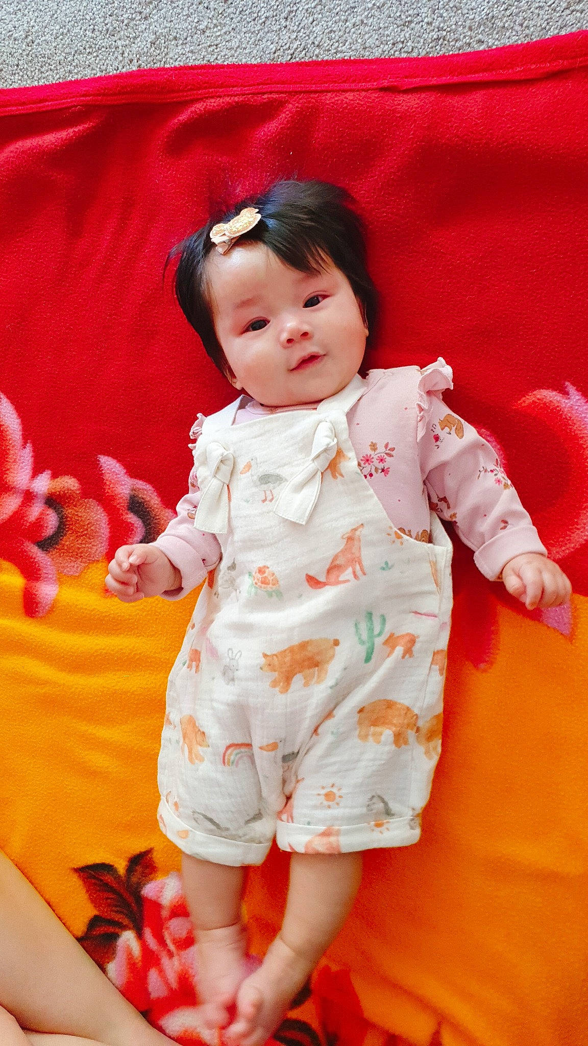 Clover is registered to the contest to win money with this photo: baby, baby_toddler_clothing, cheek, child, day_dress, dress, face, finger, happy, one_piece_garment, orange, pattern, peach, person, pink, red, skin, sleeve, smile, textile