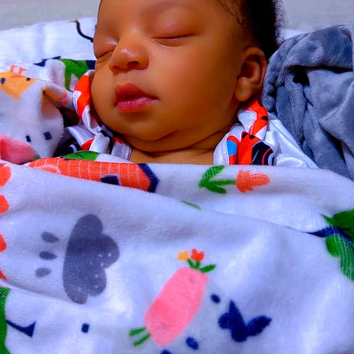 Elijah Okhiria is registered to the contest to win money with this photo: baby, blanket, child, colorful, comfort, cozy, cute, face, indoor, infant, newborn, patterned_blanket, peace, peaceful, portrait, resting, sleeping, soft_lighting, wrapped, young_child