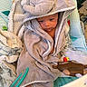 Javian is registered to the contest to win money with this photo: baby, bare_feet, blanket, child, close_up, cozy, cradle, curious, face, hooded_towel, indoor, infant, nursery, play_mat, portrait, serious_expression, sitting, textile, toy, wrapped