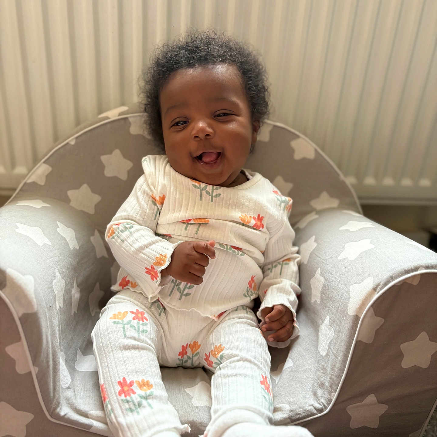 Niylah-Lai joined the competition — help win amazing prizes! baby, chair, child, cozy, curly_hair, cushion, cute, floral_outfit, happy, home, indoor, infant, person, portrait, radiator, seated, smiling, star_pattern, white_socks, young_child