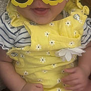 Angelina is registered to the contest to win money with this photo: baby, child, sunglasses, yellow, flower_shaped, smiling, happy, clothing, cute, infant, portrait, hands, cute_outfit, summer, fashion, accessories, closeup, playful, fun, indoor
