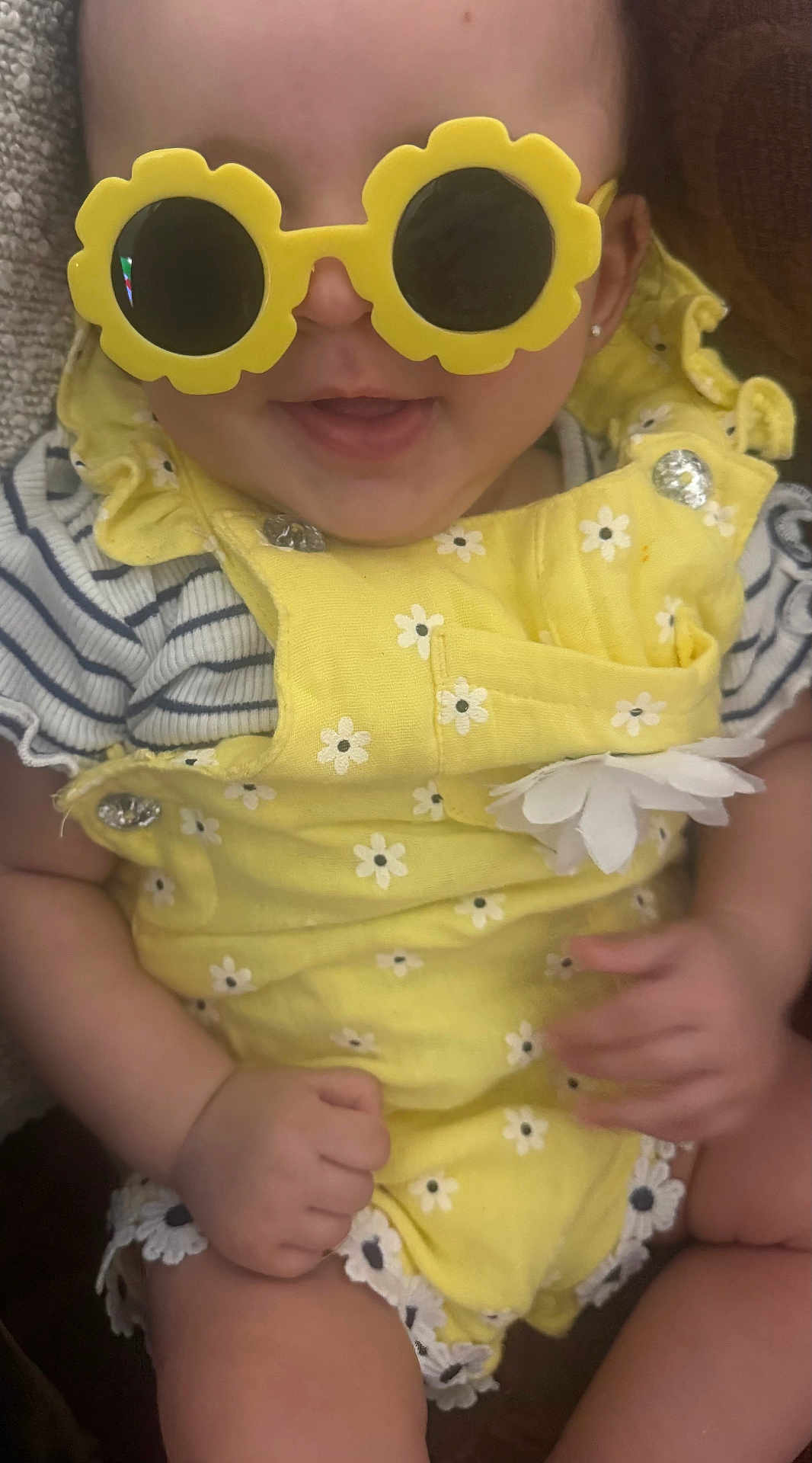 Angelina is registered to the contest to win money with this photo: baby, child, sunglasses, yellow, flower_shaped, smiling, happy, clothing, cute, infant, portrait, hands, cute_outfit, summer, fashion, accessories, closeup, playful, fun, indoor