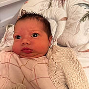 Amillia is registered to the contest to win money with this photo: baby, infant, face, eyes, blanket, knitwear, clothing, portrait, newborn, cute, indoors, skin, head, expression, lying_down, soft, warm, person, child, babywear