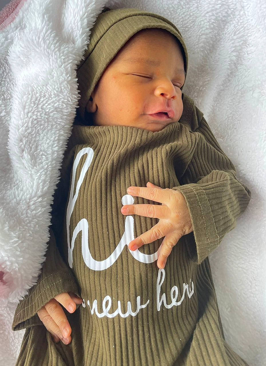 Gracious joined the competition — help win amazing prizes! baby, baby_toddler_clothing, cap, child, comfort, face, fur, gesture, happy, headgear, headwear, jacket, knit_cap, person, skin, sleeve, textile, thumb, toddler, white