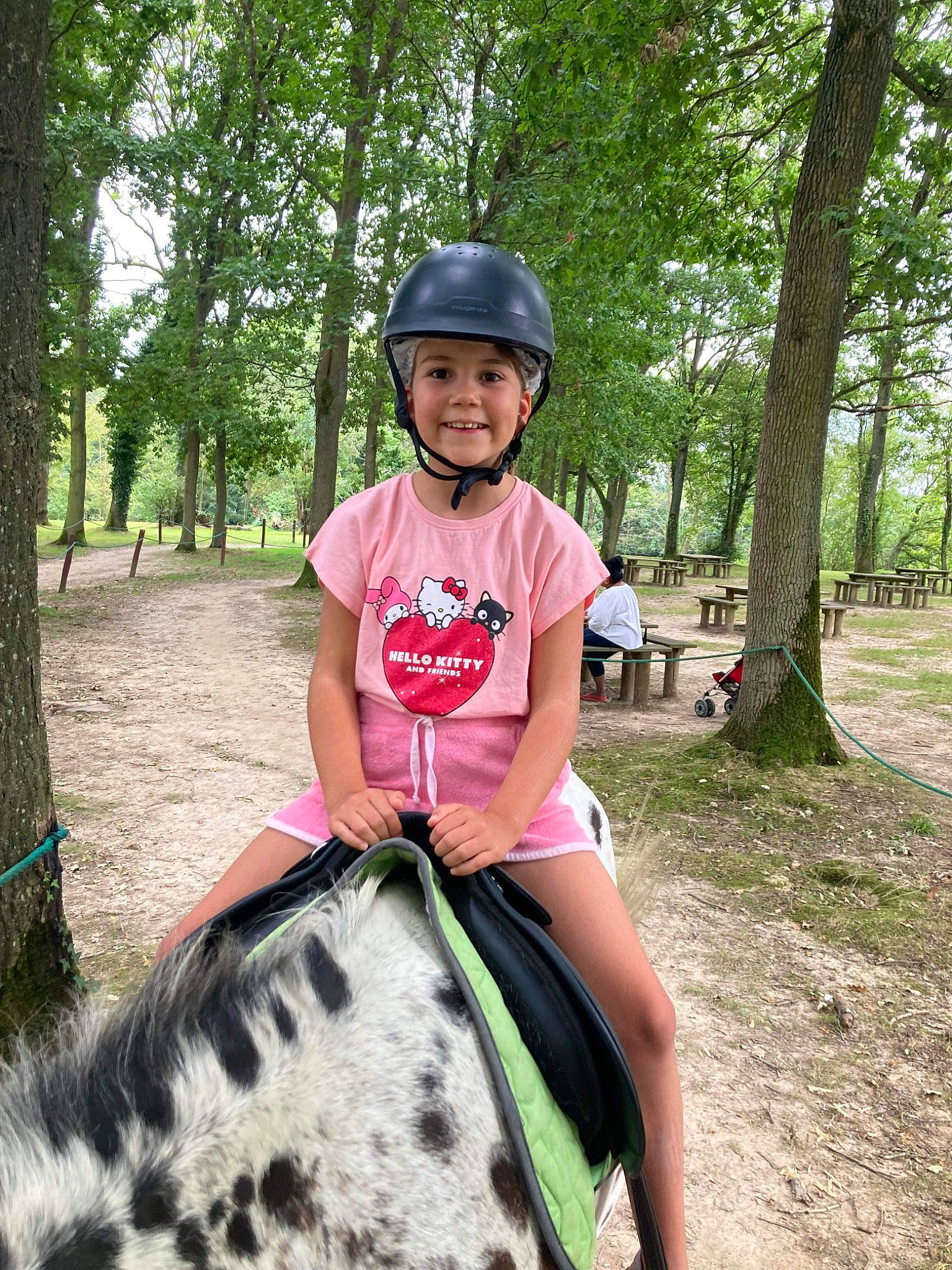 Jeanne participe au concours pour gagner de l'argent avec cette photo : bridle, equestrianism, fun, grass, headwear, helmet, horse, horse_supplies, horse_tack, joy, landscape, mammal, pack_animal, person, plant, recreation, rein, smile, summer, toddler