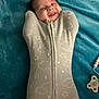 baby, smile, swaddle, blanket, blue, pacifier, infant, cozy, cute, happy, face, child, lying_down, soft, pattern, clouds, stars, zipped, indoors, newborn