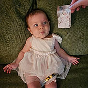 Amara joined the competition — help win amazing prizes! baby, infant, dress, couch, green, hand, photo, portrait, curious, child, fabric, texture, pink, laying, person, young, smile, cute, seated, indoors
