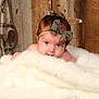 baby, infant, bow, headband, blanket, fur, wood, barrel, face, cute, portrait, indoor, soft, child, newborn, skin, expression, resting, cozy, smile