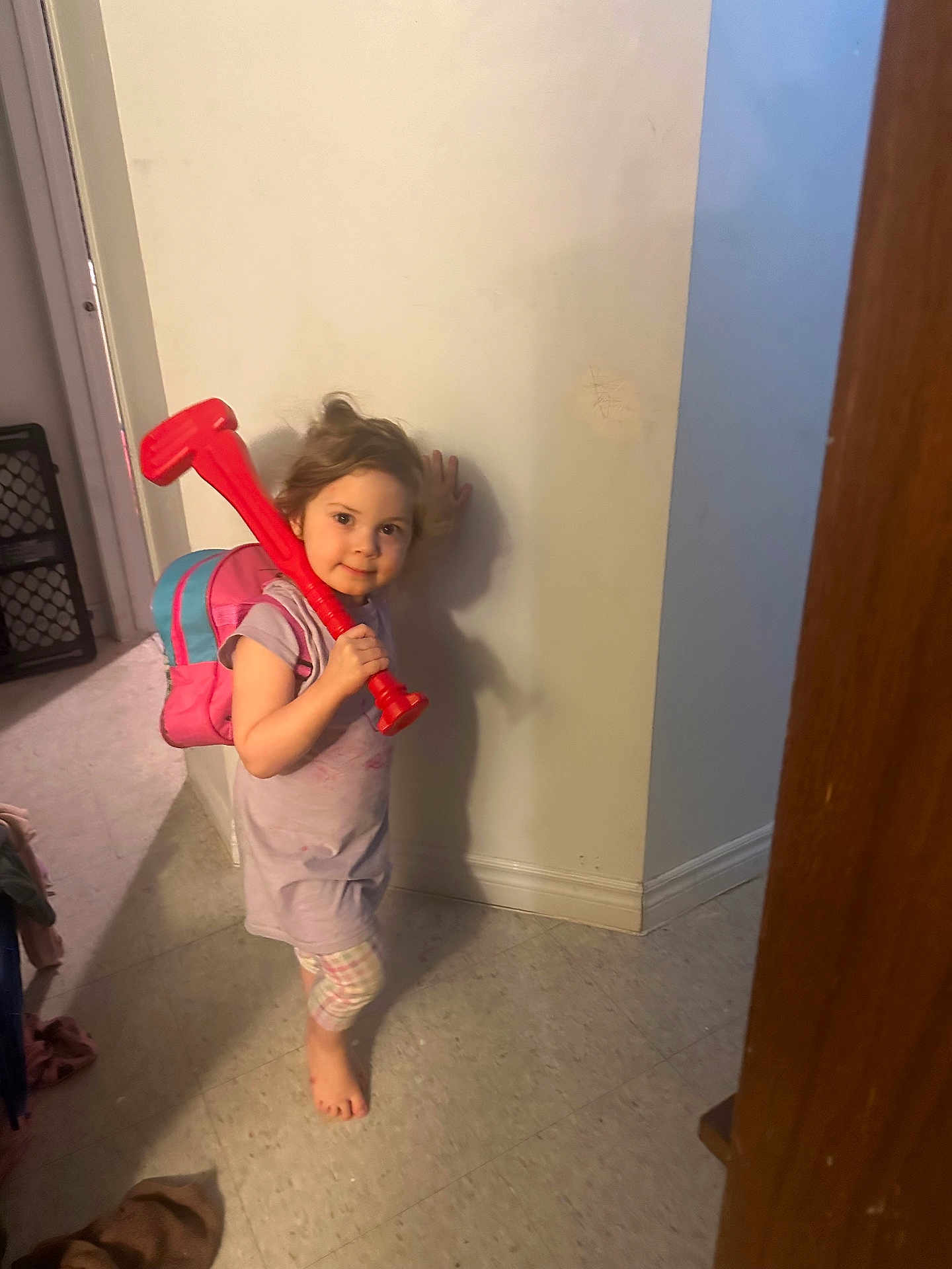 Heaven-Lleh is registered to the contest to win money with this photo: child, indoor, toy, backpack, barefoot, floor, wall, shadow, playful, curious, young, person, casual, tiled_floor, plastic_toy, smile, home, clothing, standing, light