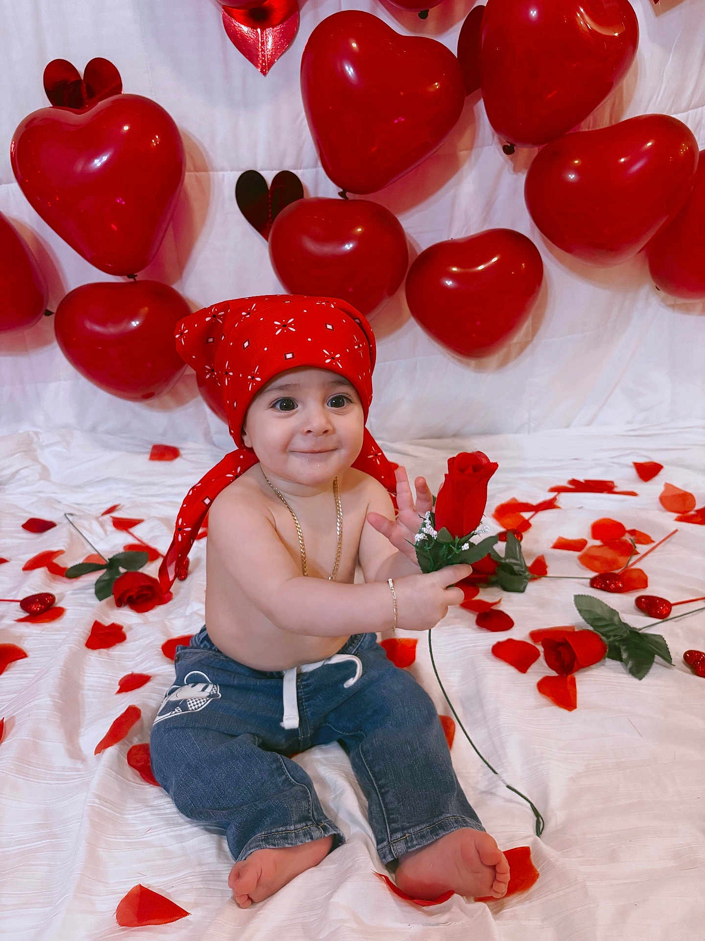 Noslen is registered to the contest to win money with this photo: baby, balloons, barefoot, big_eyes, bracelet, celebration, child, heart_balloons, infant, jeans, necklace, red_bandana, red_color, rose, rose_petals, sitting, smile, studio_shot, valentine_theme, white_backdrop