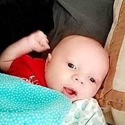 Dakota joined the competition — help win amazing prizes! baby, infant, child, portrait, face, wide_eyes, open_mouth, lying_down, blanket, bedding, bed, cozy, indoors, red_clothing, patterned_blanket, glasses, sleeping_area, close_up, surprised, cute