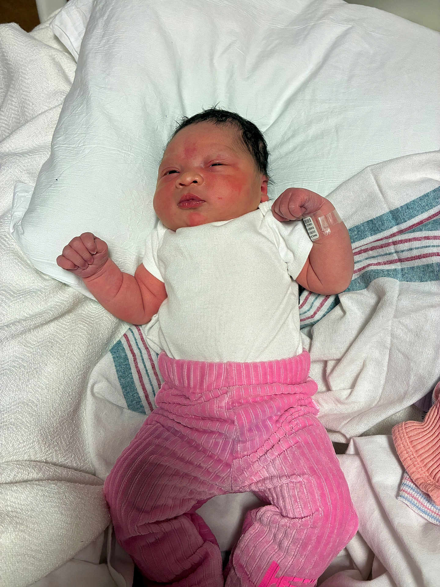 Nayali joined the competition — help win amazing prizes! newborn, baby, infant, pink_pants, white_shirt, hospital_wristband, blanket, lying_down, indoors, face, person, skin, clothing, sleepy, cute, small_hands, hospital, soft_texture, resting, portrait