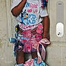 Daniya is registered to the contest to win money with this photo: child, girl, smiling, hair_bows, tshirt, skirt, ribbons, white_shoes, standing, tile_floor, door, indoor, playful, cute, happy, fashion, colorful, person, portrait, childhood