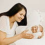 Jacklyn is registered to the contest to win money with this photo: woman, baby, smile, sleeping, swaddled, white_clothing, headband, couch, pillow, indoor, family, love, mother, newborn, gentle, cozy, soft_light, portrait, happy, tenderness