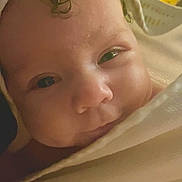 Nova is registered to the contest to win money with this photo: baby, close_up, face, blanket, curly_hair, soft_light, sleepy, wrapped, newborn, infant, cozy, warm, portrait, indoors, skin, head, cute, child, young, peaceful