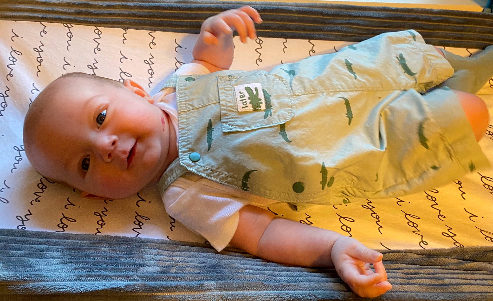 Liam is registered to the contest to win money with this photo: abdomen, baby, baby_products, baby_toddler_clothing, child, eyelash, finger, flooring, font, gesture, happy, person, skin, sleeve, smile, textile, thumb, toddler, wood, wrist