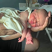 Nova is registered to the contest to win money with this photo: newborn, baby, infant, sleeping, face, hands, feet, toes, blanket, swaddling, parent, holding, cradling, indoors, bedroom, teddy_bear, flowers, portrait, family, cozy