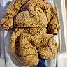 newborn, baby, sleeping, onesie, fluffy, teddy_bear, blue_sock, baby_changing_pad, infant, cozy, cute, child, soft, warm_clothing, indoors, resting, peaceful, face, head, small_hand