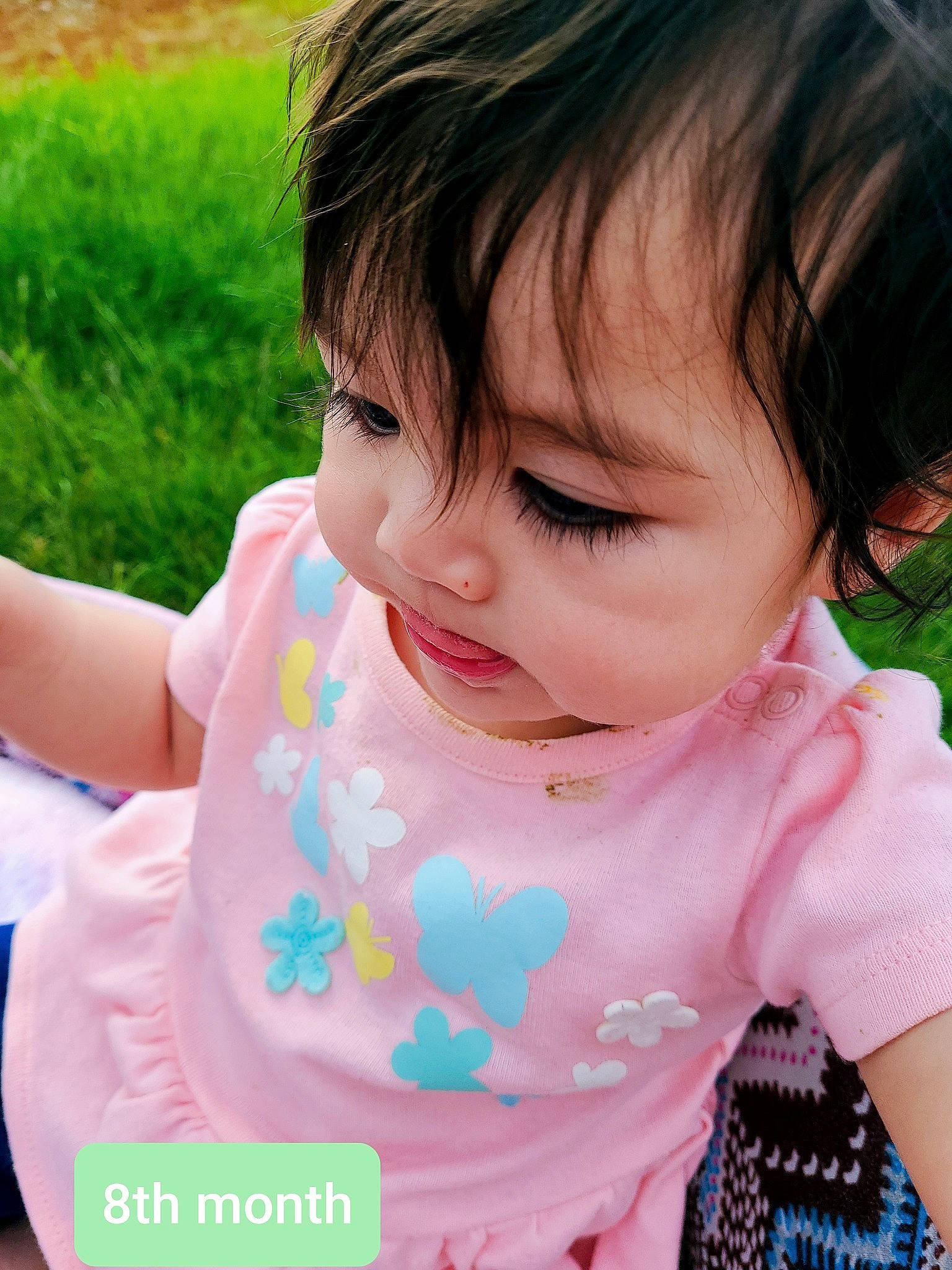 Arya is registered to the contest to win money with this photo: baby, beauty, black_hair, brown_hair, cheek, child, eye, eyelash, grass, hair, lip, mouth, nose, person, pink, plant, play, skin, toddler