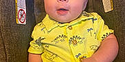 Oliver joined the competition — help win amazing prizes! baby, infant, child, car_seat, yellow_outfit, dinosaur_print, cute, smiling, portrait, indoor, clothing, hands, face, eyes, seated, young_child, happy, casual, closeup, comfortable