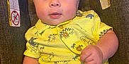 Oliver is registered to the contest to win money with this photo: baby, infant, child, yellow_clothing, dinosaur_pattern, car_seat, seat_belt_warning, curious_expression, indoor, portrait, cute, soft_lighting, small_hands, buttoned_shirt, short_sleeves, close_up, person, human, adorable, seated