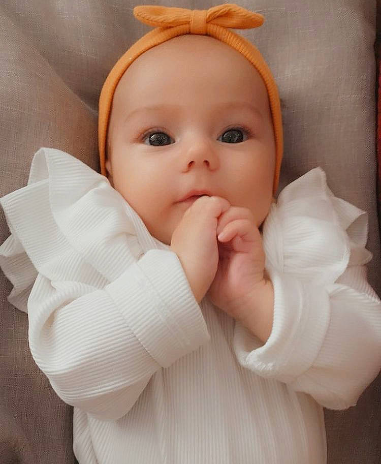 Mia participe au concours pour gagner de l'argent avec cette photo : baby, baby_toddler_clothing, cheek, comfort, eye, eyebrow, eyelash, finger, gesture, head, iris, lip, nail, nose, person, product, skin, sleeve, textile, thumb