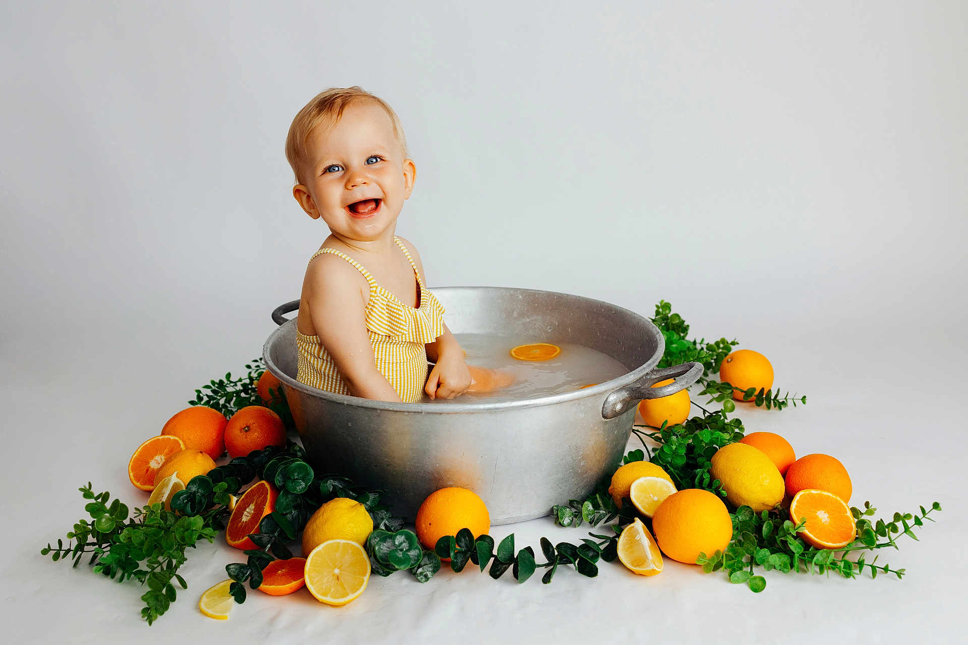 Abigaëlle a rejoint le concours — aidez-le/la à gagner de superbes lots ! toddler, child, smiling, metal_basin, water, yellow_swimsuit, orange, lemon, citrus_fruit, green_leaves, fruit_slices, happy, sitting, indoor, studio, portrait, cute, playful, summer, fresh