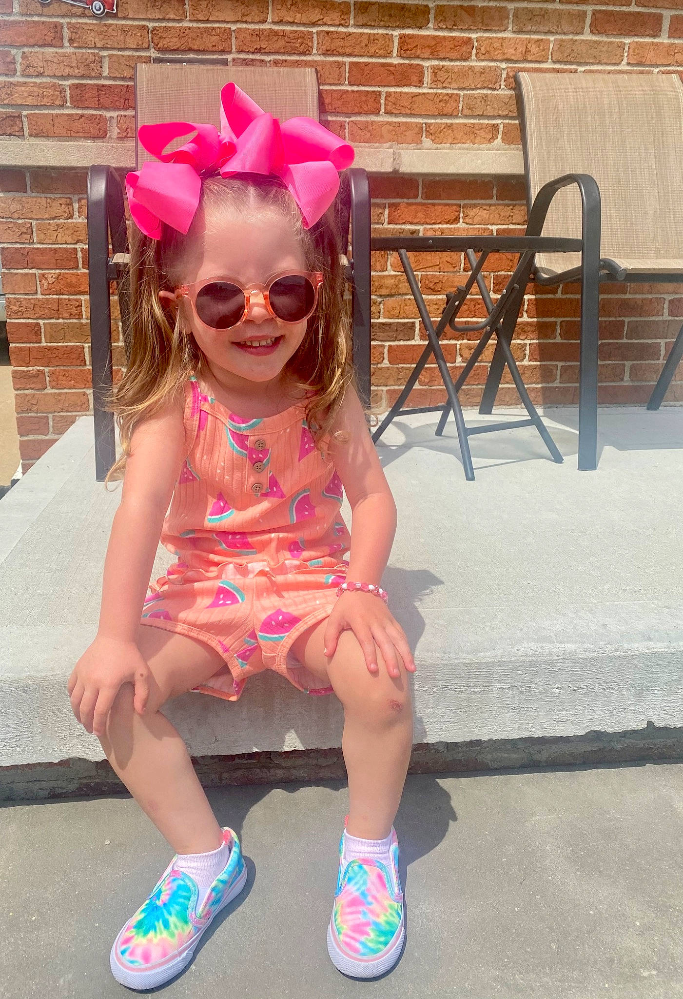 Milena is registered to the contest to win money with this photo: baby_toddler_clothing, clothing, dress, eyewear, goggles, hairstyle, happy, head, headgear, joy, leg, leisure, person, pink, purple, shoe, sleeve, smile, standing, sunglasses