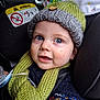 airbag_sign, baby, blue_eyes, car_interior, car_seat, child, closeup, cute, expression, face, indoors, infant, knitted_hat, knitted_scarf, pacifier, portrait, seatbelt, warm_clothing, winter_clothing, young_child