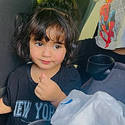 Sally joined the competition — help win amazing prizes! child, toddler, girl, car, car_interior, backseat, portrait, smiling, thumbs_up, dark_hair, bangs, black_shirt, new_york_shirt, plastic_bag, bowl, cup, passenger, phone_screenshot, outdoor_light, family_trip