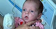 Kyleigh joined the competition — help win amazing prizes! baby, infant, hand, hospital_bed, medical_equipment, pink_clothing, person, newborn, adult_hand, bed_control_panel, curious_expression, indoors, healthcare, closeup, skin, face, holding, hospital, patient, care