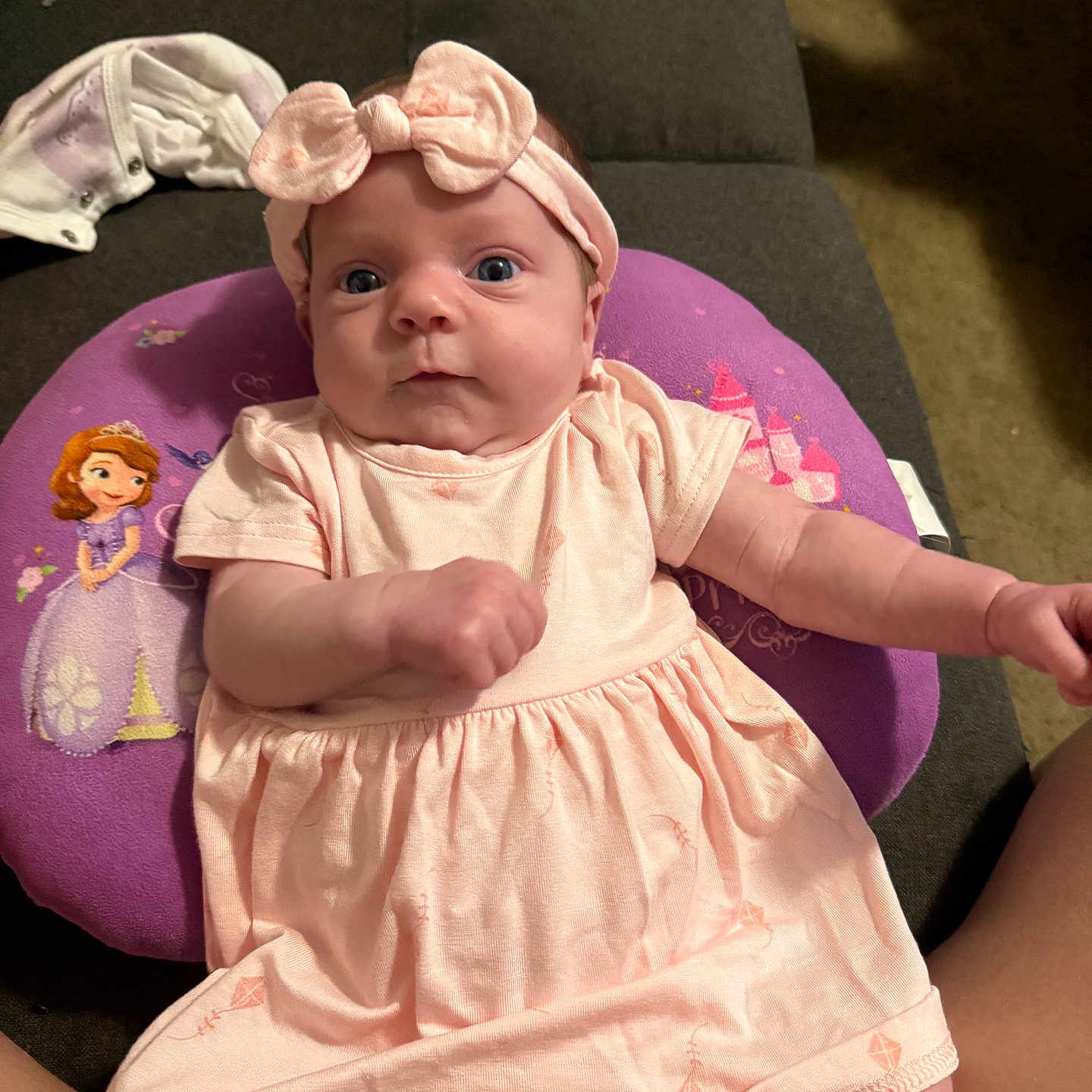 Kyleigh joined the competition — help win amazing prizes! baby, infant, pink_dress, headband, bow, purple_pillow, princess, couch, indoor, person, child, wide_eyes, cute, soft_lighting, portrait, seated, comfortable, clothing, baby_girl, home