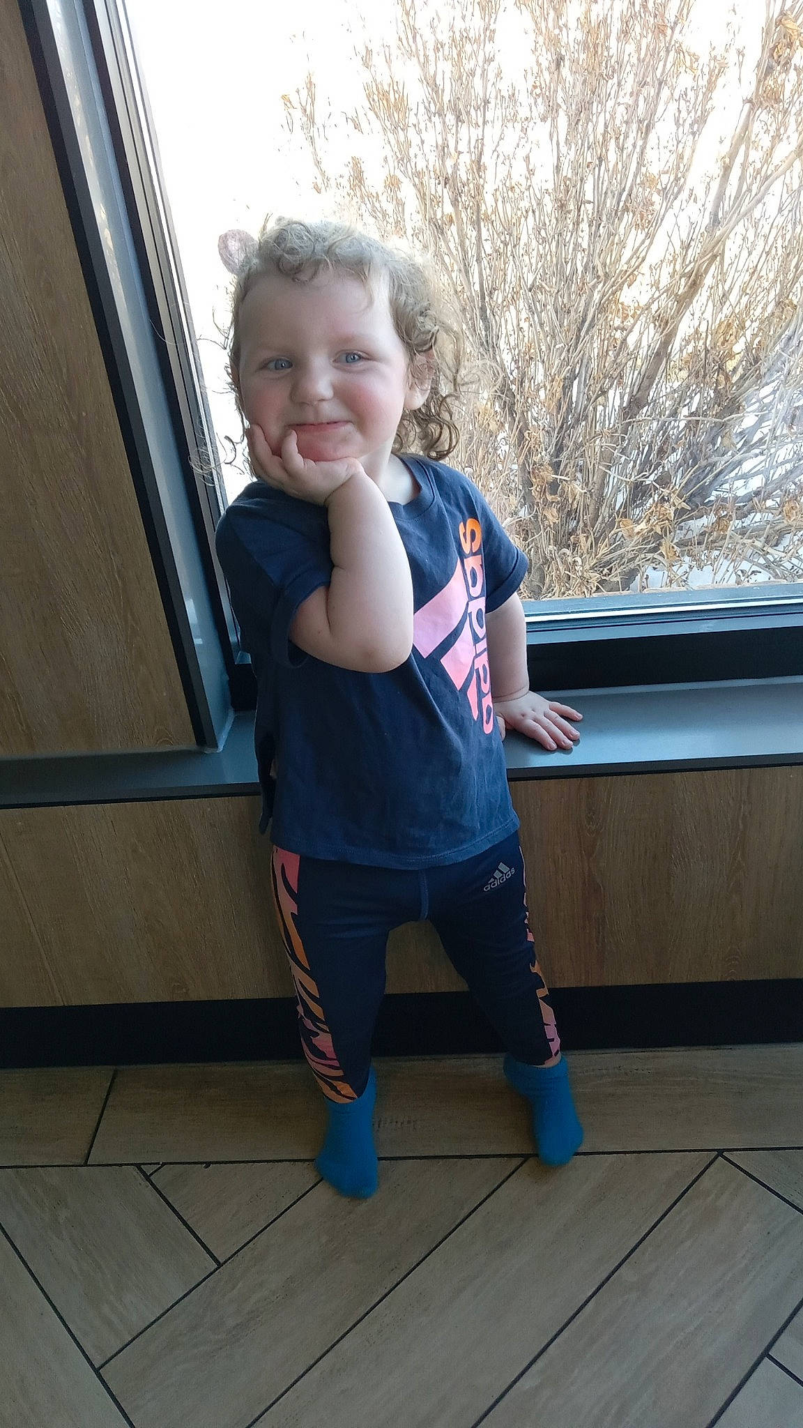Amiyah is registered to the contest to win money with this photo: electric_blue, face, fun, happy, head, joint, joy, knee, leg, leisure, person, shoulder, sleeve, smile, sportswear, standing, thigh, toddler, tree, waist