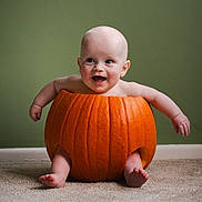 Jesse is registered to the contest to win money with this photo: baby, pumpkin, carpet, green_wall, smiling, arms_outstretched, barefoot, cute, indoor, child, hollow_pumpkin, happy, sitting, orange, round, photography, portrait, infant, playful, fun