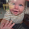 baby, blue_eyes, child, close_up, curious, cute, expression, face, fingertips, glass, hand, indoor, person, portrait, reflection, skin, smiling, striped_shirt, window, young_child