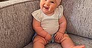Kamryn joined the competition — help win amazing prizes! baby, child, smile, headband, pink_bow, couch, gray_couch, sitting, happy, indoors, cute, infant, shorts, white_shirt, plush_furniture, portrait, chubby_arms, chubby_legs, home, cozy