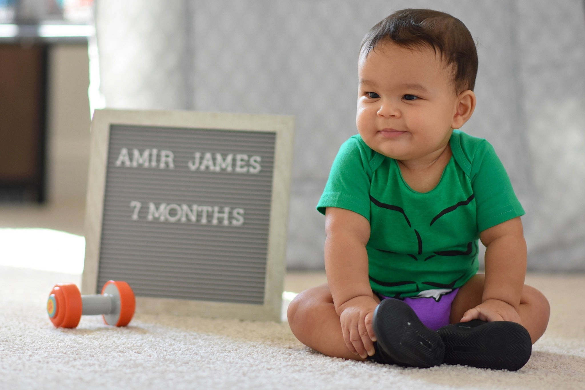 Amir joined the competition — help win amazing prizes! baby, baby_playing_with_toys, baby_toddler_clothing, carmine, child, flooring, font, fun, grass, happy, knee, leisure, person, portrait_photography, sitting, sleeve, smile, sock, t_shirt, toddler